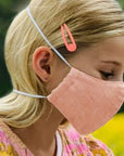 Girl Wearing a Kind Face Reusable Linen Face Mask in Soft Pink Colour