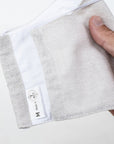A Hand Holding a Kind Face Reusable Linen Face Mask in Natural Colour