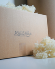 A Kind Face Box with Kind Face Loose Cloud Wool Fill on Top and in Front of it