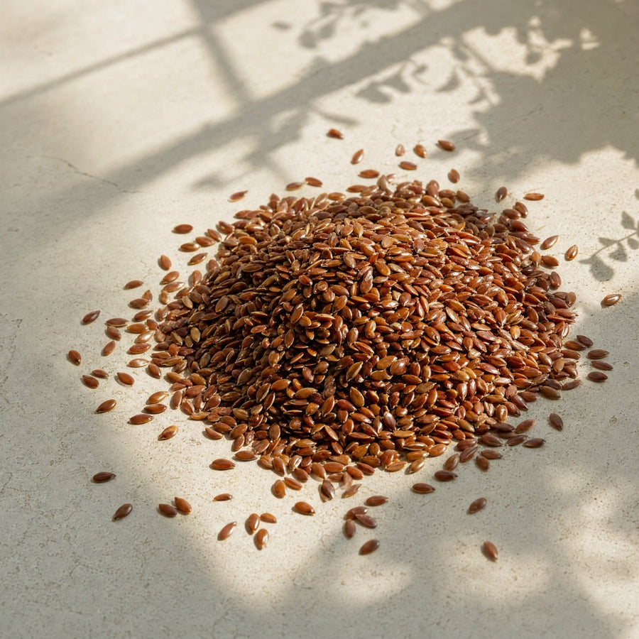 Pile of flaxseeds on a light surface with shadows