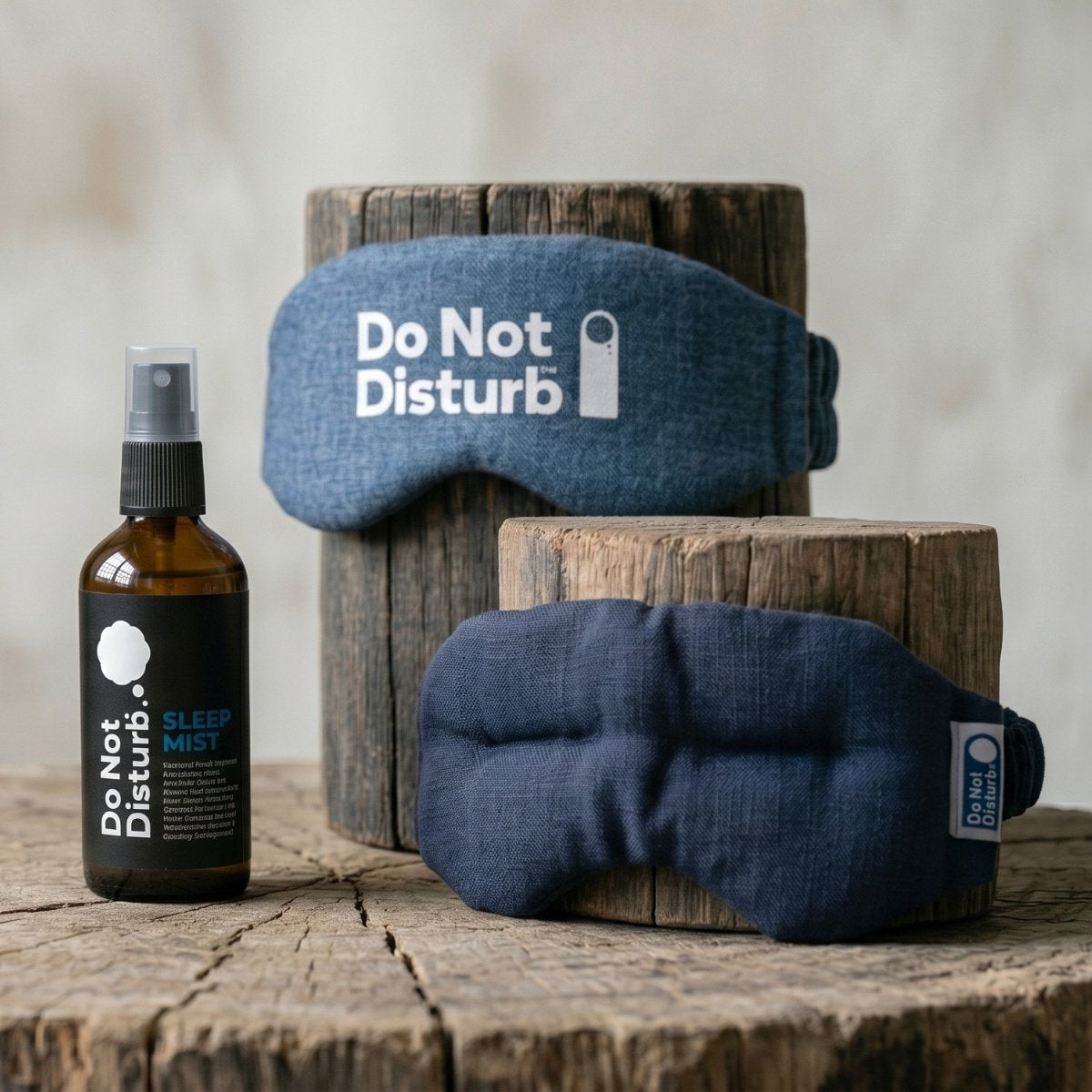 Sleep mask and bottle of sleep mist with 'Do Not Disturb' text on a wooden surface.