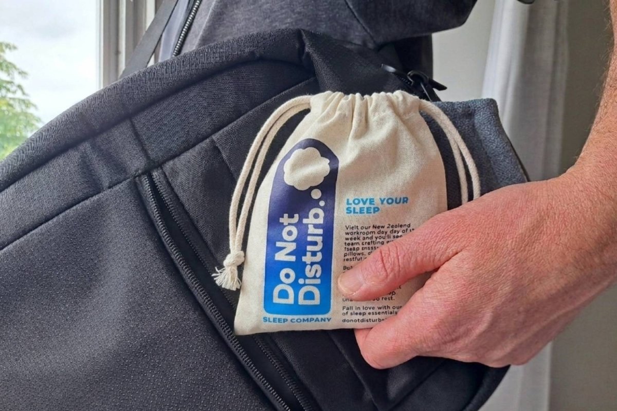 A hand holding the Do Not Disturb 'Love Your Sleep' cotton pouch 